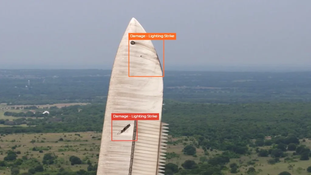 AI-powered object detection identifying two areas of "Lightning Strike" damage on a large wind turbine blade from an aerial view