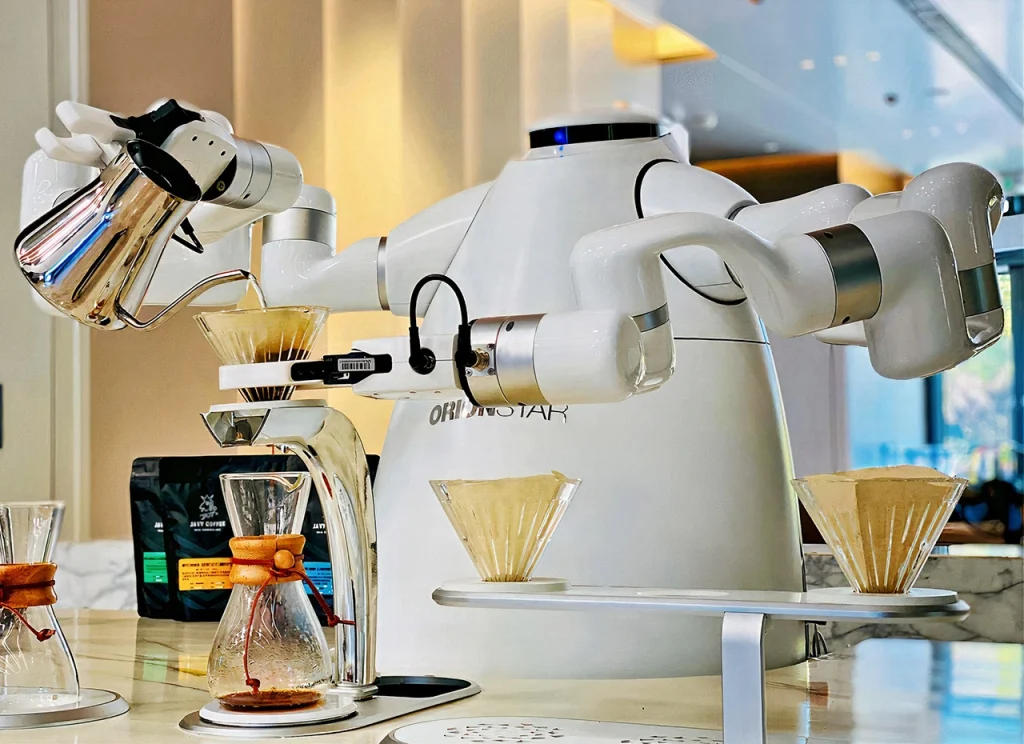 A multi-armed white AI barista robot from OrionStar carefully making pour-over coffee with precision and skill