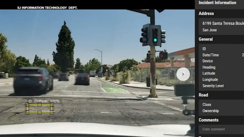 Dashcam view showing an AI system detecting a pothole on the road with 100% confidence and logging the incident information