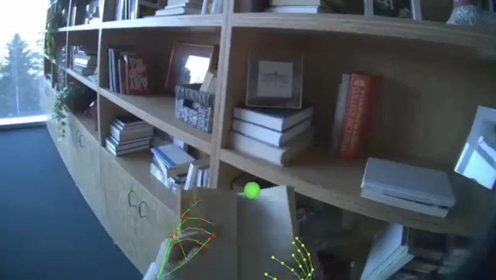 First-person view of hands opening a book, with an AI overlay showing hand pose estimation for augmented reality applications
