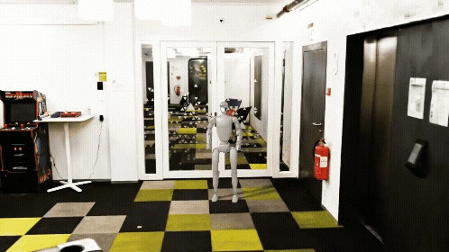 A humanoid robot demonstrating bipedal walking and navigation in an office environment, showcasing advanced AI locomotion